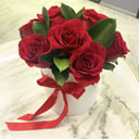 Красные розы с зеленью в шляпной коробке