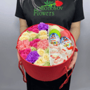 Цветы в круглой коробочке со сладостями из роз и гвоздик